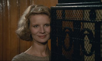 Movie still from “Waiter!” (1983), directed by Claude Sautet – A woman standing next to a metal cage; Close Up shot, Low angle