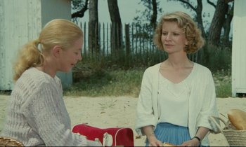Movie still from “Waiter!” (1983), directed by Claude Sautet – Two women are standing outside talking to each other; Medium shot, Over the shoulder angle