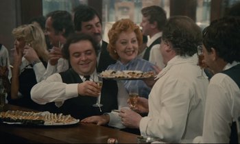 Movie still from “Waiter!” (1983), directed by Claude Sautet – A group of people are gathered around a table; Wide shot, High angle