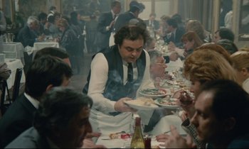 Movie still from “Waiter!” (1983), directed by Claude Sautet – A group of people sitting at a table with food; Wide shot, High angle