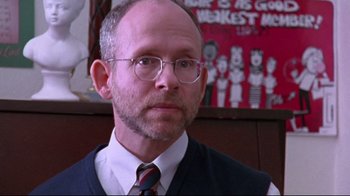 Movie still from “Waiting for Guffman” (1996), directed by Christopher Guest – A man in a vest and tie is looking at the camera; Close Up shot, Over the shoulder angle