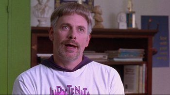 Movie still from “Waiting for Guffman” (1996), directed by Christopher Guest – A person wearing a t - shirt; Close Up shot, Over the shoulder angle