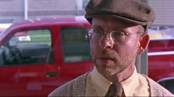 Movie still from “Waiting for Guffman” (1996), directed by Christopher Guest – An older man wearing glasses and a hat; Close Up shot, Over the shoulder angle