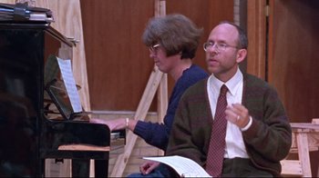 Movie still from “Waiting for Guffman” (1996), directed by Christopher Guest – A man and a woman sitting in front of an upright piano; Medium shot, High angle