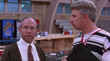 Movie still from “Waiting for Guffman” (1996), directed by Christopher Guest – Two men are standing in a room talking to each other; Medium shot, Over the shoulder angle