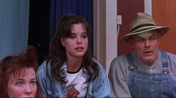 Movie still from “Waiting for Guffman” (1996), directed by Christopher Guest – A young woman sitting next to an older man in a room; Medium shot, Over the shoulder angle