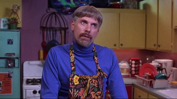 A man in a blue shirt is wearing an apron