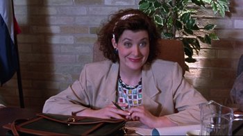 Movie still from “Waiting for Guffman” (1996), directed by Christopher Guest – A woman sitting at a table in a room; Medium shot, High angle