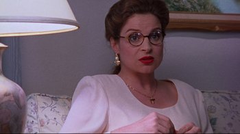 Movie still from “Waiting for Guffman” (1996), directed by Christopher Guest – A woman wearing glasses and a white dress; Close Up shot, Over the shoulder angle