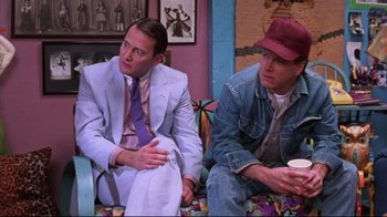 Movie still from “Waiting for Guffman” (1996), directed by Christopher Guest – A couple of men sitting next to each other on a couch; Medium shot, Over the shoulder angle