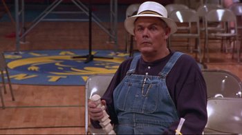 Movie still from “Waiting for Guffman” (1996), directed by Christopher Guest – An older man wearing a white hat and overalls; Medium shot, High angle