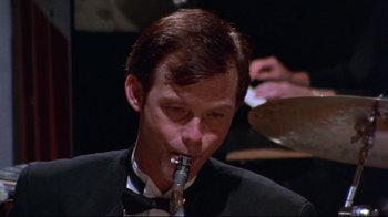 Movie still from “Waiting for Guffman” (1996), directed by Christopher Guest – A person wearing a suit and bow tie; Close Up shot, High angle