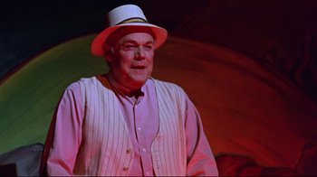 Movie still from “Waiting for Guffman” (1996), directed by Christopher Guest – An older man wearing a white hat and a striped vest; Medium shot, Low angle