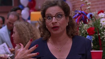 Movie still from “Waiting for Guffman” (1996), directed by Christopher Guest – A woman wearing glasses and a blue top; Close Up shot, High angle