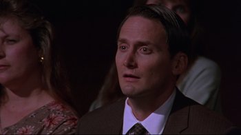 Movie still from “Waiting for Guffman” (1996), directed by Christopher Guest – A man in a suit and tie looking to his left; Close Up shot, High angle