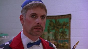 Movie still from “Waiting for Guffman” (1996), directed by Christopher Guest – A person with a bow tie; Close Up shot, Over the shoulder angle