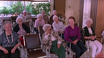 Movie still from “Waiting for Guffman” (1996), directed by Christopher Guest – A group of older women sitting in a room; Wide shot, High angle