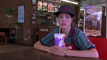 Movie still from “Waiting for Guffman” (1996), directed by Christopher Guest – A woman sitting at a table holding a cup of coffee; Medium shot, Low angle