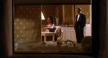 Movie still from “Waiting to Exhale” (1995), directed by Forest Whitaker – A man and a woman are sitting at a dinner table; Medium shot, Over the shoulder angle