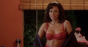 Movie still from “Waiting to Exhale” (1995), directed by Forest Whitaker – A woman in a red bra is posing for a picture; Medium shot, Over the shoulder angle