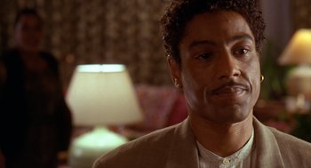 Movie still from “Waiting to Exhale” (1995), directed by Forest Whitaker – A person wearing a suit and tie; Close Up shot, Over the shoulder angle