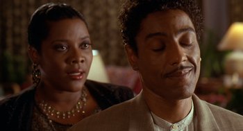 Movie still from “Waiting to Exhale” (1995), directed by Forest Whitaker – A man and a woman sitting next to each other in a room; Close Up shot, Over the shoulder angle