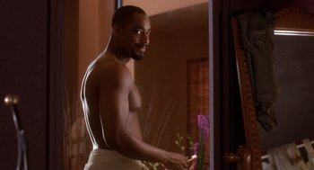 Movie still from “Waiting to Exhale” (1995), directed by Forest Whitaker – A man in a towel standing in front of a bathroom mirror; Medium shot, Over the shoulder angle
