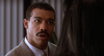 Movie still from “Waiting to Exhale” (1995), directed by Forest Whitaker – A person wearing a suit and tie; Close Up shot, Over the shoulder angle