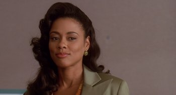 Movie still from “Waiting to Exhale” (1995), directed by Forest Whitaker – A woman in a green jacket and a yellow necklace; Close Up shot, Over the shoulder angle