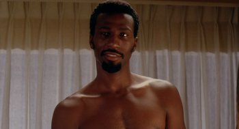 Movie still from “Waiting to Exhale” (1995), directed by Forest Whitaker – A man with a beard is posing for a picture; Close Up shot, Low angle