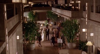 Movie still from “Waiting to Exhale” (1995), directed by Forest Whitaker – A group of people standing in a room with potted plants; Wide shot, High angle