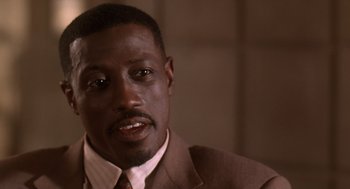 Movie still from “Waiting to Exhale” (1995), directed by Forest Whitaker – A person wearing a suit and tie; Close Up shot, Low angle
