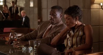 Movie still from “Waiting to Exhale” (1995), directed by Forest Whitaker – A man and a woman sitting next to each other at a table; Medium shot, High angle