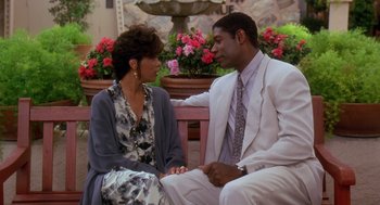Movie still from “Waiting to Exhale” (1995), directed by Forest Whitaker – A man and a woman sitting next to each other on top of a bench; Medium shot, High angle