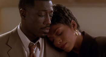 Movie still from “Waiting to Exhale” (1995), directed by Forest Whitaker – A man and a woman snuggled up close to one another; Close Up shot, High angle