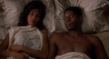 Movie still from “Waiting to Exhale” (1995), directed by Forest Whitaker – A man and a woman laying in a bed together; Medium shot, Overhead angle