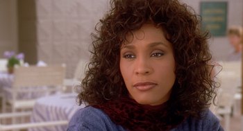 Movie still from “Waiting to Exhale” (1995), directed by Forest Whitaker – A person with curly hair wearing a scarf; Close Up shot, High angle