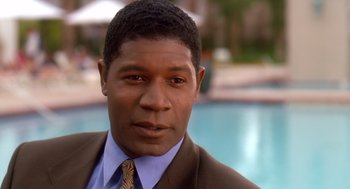 Movie still from “Waiting to Exhale” (1995), directed by Forest Whitaker – A person wearing a suit near a pool; Close Up shot, High angle