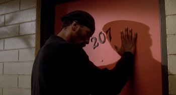 Movie still from “Waiting to Exhale” (1995), directed by Forest Whitaker – A man touching a wall with numbers painted on it; Close Up shot, Low angle