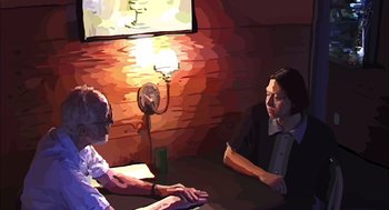 Movie still from “Waking Life” (2001), directed by Richard Linklater – Two people sitting at a table in front of computers; Medium shot, Over the shoulder angle