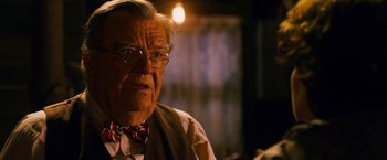 Movie still from “Walk Hard: The Dewey Cox Story” (2007), directed by Jake Kasdan – An old man wearing glasses and a bow tie; Close Up shot, Over the shoulder angle