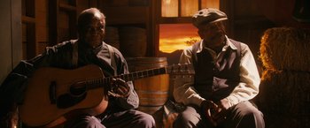 Movie still from “Walk Hard: The Dewey Cox Story” (2007), directed by Jake Kasdan – Two older men sitting next to each other with a guitar; Medium shot, Low angle