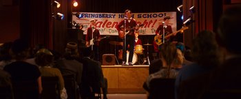 Movie still from “Walk Hard: The Dewey Cox Story” (2007), directed by Jake Kasdan – A group of young men performing on a stage; Wide shot, High angle