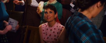 Movie still from “Walk Hard: The Dewey Cox Story” (2007), directed by Jake Kasdan – A woman sitting in front of a group of other people; Close Up shot, Over the shoulder angle