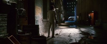 Movie still from “Walk Hard: The Dewey Cox Story” (2007), directed by Jake Kasdan – A man in a white suit standing in a dark alley; Wide shot, Over the shoulder angle