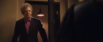Movie still from “Walk Hard: The Dewey Cox Story” (2007), directed by Jake Kasdan – A man standing in front of a mirror in a room; Medium shot, Over the shoulder angle