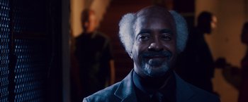 Movie still from “Walk Hard: The Dewey Cox Story” (2007), directed by Jake Kasdan – An older man with a beard is smiling for the camera; Close Up shot, Over the shoulder angle