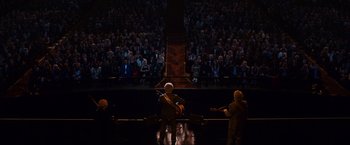 Movie still from “Walk Hard: The Dewey Cox Story” (2007), directed by Jake Kasdan – A man playing a guitar in front of an audience; Extreme Wide shot, High angle