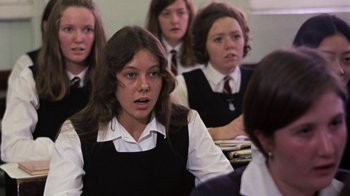 Movie still from “Walkabout” (1971), directed by Nicolas Roeg – A group of young people in school uniforms sitting in a class room; Medium shot, Over the shoulder angle