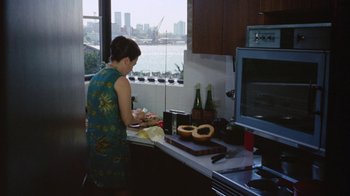 Movie still from “Walkabout” (1971), directed by Nicolas Roeg – A woman in a green dress in a kitchen; Wide shot, High angle